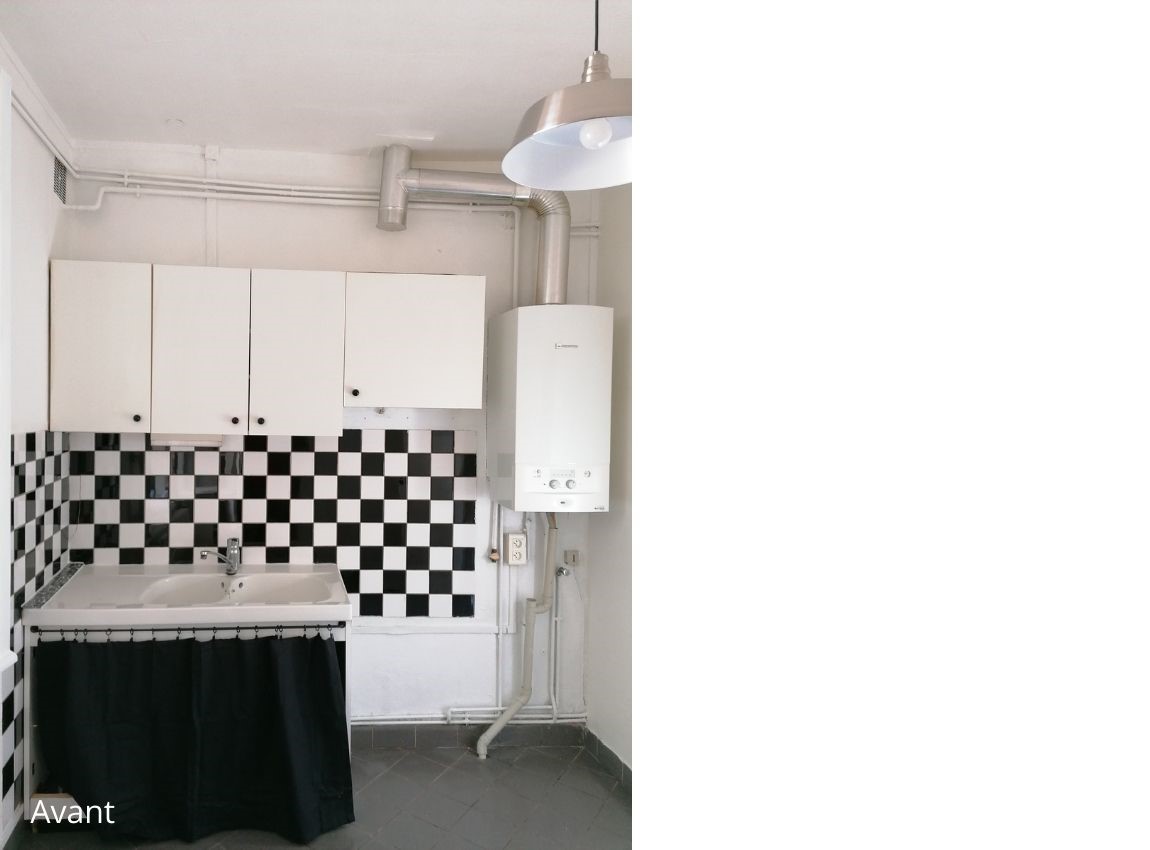 Ancienne cuisine avec 4 placards blanc au mur et un grand évier en faïence blanche. Un rideaux noir ferme le placard qui le soutien. Un chauffe eau. Pas de plan de travail.