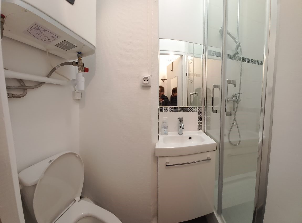Salle de bain refaite, carreaux blancs avec une jolie frise de carreaux noirs et argentés dans la douche neuve fermée par deux portes battantes. Toilette et nouveau chauffe eaux au dessus. Le but étant de ne plus le voir dans la cuisine et de gagner de la place. Petit espace très optimisé.
