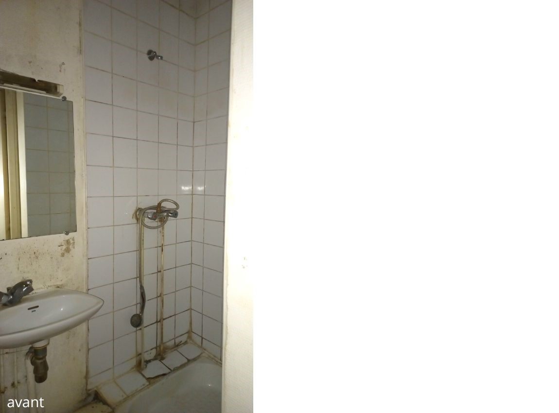 Ancienne douche carreaux blanc cassé et joints salle. Vue du petit lavabo sale. Murs jauni et sale.
